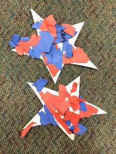 three red, white and blue paper airplanes are on the floor next to each other