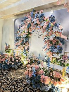 a wedding ceremony with flowers on the wall