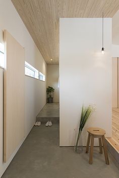 an empty room with two stools and a potted plant on the side wall