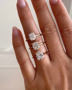 a woman's hand with three different rings on her fingers and one has two diamonds in the middle