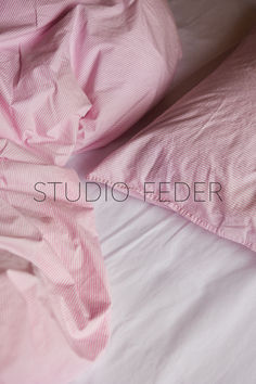 an unmade bed with pink sheets and pillows