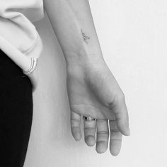 a woman's hand with a small airplane tattoo on her left inner arm and wrist