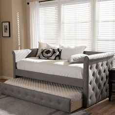 a living room scene with focus on the daybed and window blinds in the background