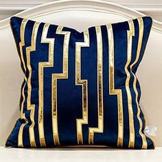 a blue and gold pillow sitting on top of a white couch