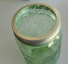 a green mason jar sitting on top of a table