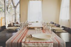 a dining room table set with place settings