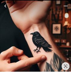 a person with a black bird tattoo on their arm