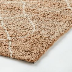 an area rug with white and beige colors on the floor, closeup view from above