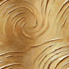 a close up view of gold paint swirling in the air and on top of it