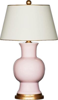 a pink table lamp with a white shade on the top and gold trim around the base