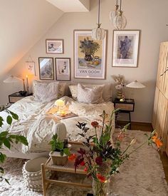 a bedroom with white bedding and pictures on the wall