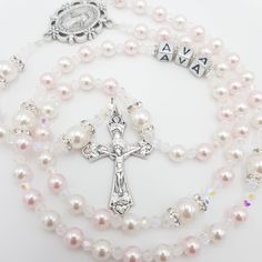 Elegant and dainty Rosary beads made with alternateing white and pink Swarovski beads for Hail Mary and complimented by beautiful white Swarovski beads for Our Father with shimmering rhinestone spacers. Suitable gift for many occasions such as a christening for baby girl, first holy communion, baptism, confirmation, wedding rosary and much more! Add a name and/or Saint pendant to personalise and choose your own centrepiece with a wide variety available. Please select whether you would like to a White Rosary With Round Beads For Confirmation, White Pearl Rosary For Baptism, Personalized White Rosary For Confirmation, Elegant White Rosary For Baptism, Handmade White Rosary For Baptism, Adjustable White Rosary For First Communion, Pink Beaded Jewelry For First Communion, Handmade Pink Jewelry For Baptism, Personalized White Rosary