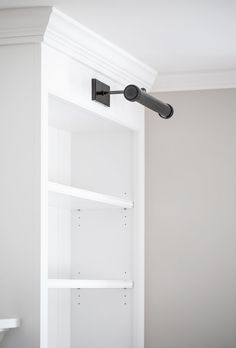 a bathroom with white shelves and black fixtures