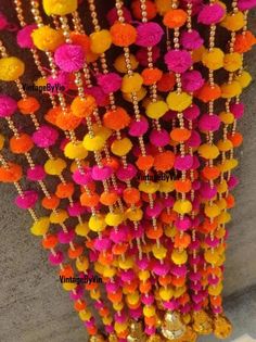 many colorful pom poms hanging from the ceiling