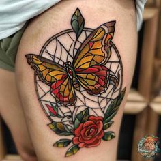 a woman's thigh with a butterfly and rose tattoo on it