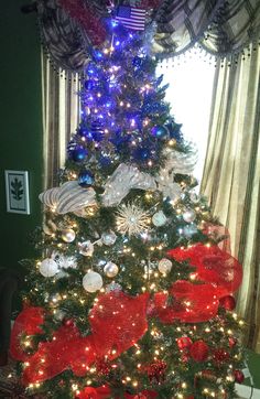 the christmas tree is decorated with red, white and blue ornaments