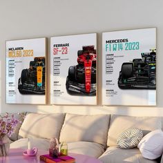 three racing cars are displayed on the wall in this living room with white couches