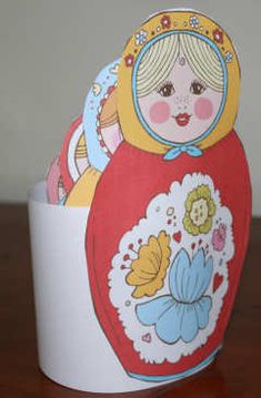 an egg shaped like a doll sitting on top of a table