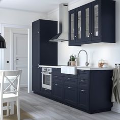 a kitchen with dark blue cabinets and white counter tops