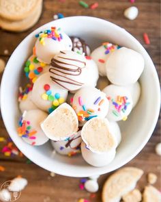 a bowl filled with white chocolate covered donuts and sprinkles