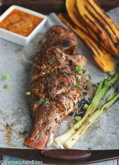 grilled fish and asparagus on a baking sheet