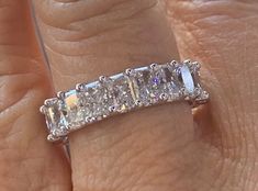 a woman's hand with a diamond ring on top of her finger and an engagement band in the middle