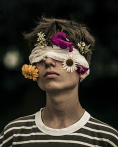 a young man with flowers in his hair