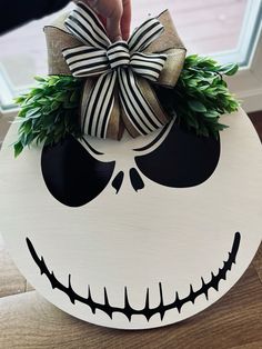 a hand is holding a halloween decoration with a bow on it's head and eyes