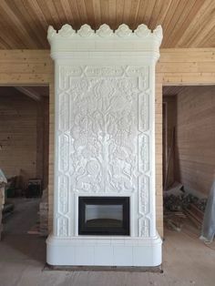 a large white fireplace sitting inside of a living room next to a wooden wall and ceiling