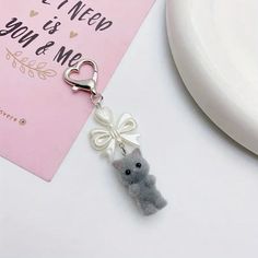 a keychain with a small teddy bear attached to it's side on a table