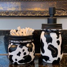 two black and white jars sitting on top of a counter