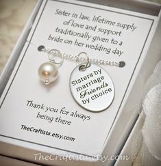 a gift box with two necklaces and a card on it that says sister in law