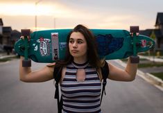 a woman holding a skateboard over her head