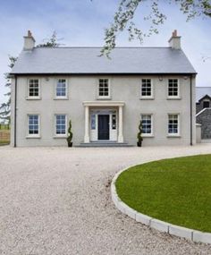 a large white house sitting on top of a lush green field