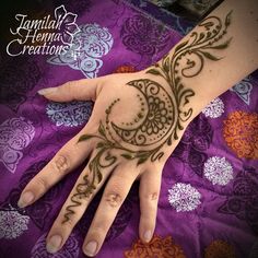 a woman's hand with henna tattoos on it