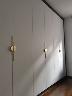 an empty room with white cabinets and wood floors