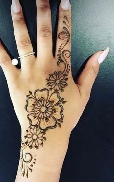 a woman's hand with henna tattoos on it