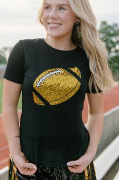 Get ready for game day with our Black Sequin Gameday Tee! With a bold black and gold color scheme, this tee features a sequin football on the front for added flair. The short sleeves and stretchy, fitted design make it both comfortable and stylish. Show your support for the New Orleans Saints and stand out from the crowd with this must-have tee. runs slightly small with stretch model, Ashlyn is wearing a size small Black Collegiate T-shirt For Cheerleading, Black Sports Fan T-shirt For Cheerleading, Black T-shirt For Game Day Football Season, Black Glitter Print T-shirt For Cheerleading, Black T-shirt For Game Day In Fall, Black T-shirt For Fall Game Day, Game Day Team Spirit T-shirt With Glitter Print, Team Spirit T-shirt For Game Day With Glitter Print, Black Sequin Short Sleeve T-shirt