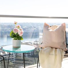 a chair and table on a balcony overlooking the city