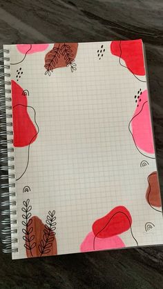 a spiral notebook with red and orange leaves on it