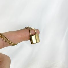 a person's finger with a padlock on it and a chain around the thumb