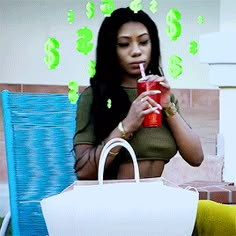 a woman sitting in a chair drinking from a straw