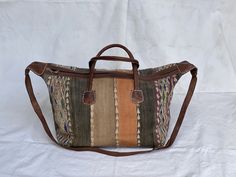 "Made to look old vintage kilim bag Vintage kilim & leather weekender bag made of berber carpet & cow hide great boho travel luggage carry on moroccan bohemian handbag Handcrafted bag by a talented artisan of Marrakech - morocco.   This is Handmade and authentic vintage moroccan leather and kilim bag.  This is a one of a kind bag, the old kilim rug was cut and then sewn on leather to give this awesome fashionable look .  This handcrafted Moroccan leather duffel features a fully-lined main compartment with zipper entry and two exterior buckled flap pockets Measures 24\" x 14\" x 11\"  Made of old kilim rug A strap Two leather pockets Comes with some minor imperfections" Bohemian Leather Rectangular Travel Bag, Bohemian Leather Travel Bag, Bohemian Rectangular Duffle Bag With Leather Handles, Bohemian Duffle Bag With Leather Handles, Bohemian Satchel Duffle Bag For Trips, Traditional Tote Travel Bag With Leather Handles, Traditional Travel Tote Bag With Leather Handles, Bohemian Leather Tote Travel Bag, Bohemian Leather Tote Duffle Bag