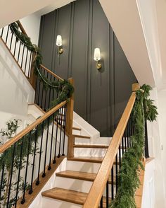 the stairs are decorated with christmas garland and lights on each handrail for an elegant touch