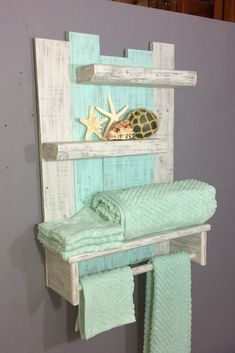 a towel rack made out of pallet wood with sea shells and starfish on it