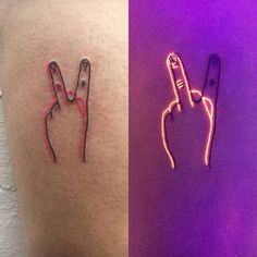 two different colored tattoos on the side of someone's thigh and one with a finger sign