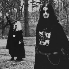 two people dressed up in black and white are standing near each other with their faces painted