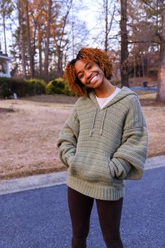 a woman standing in the street smiling and wearing leggings with her hands on her hips