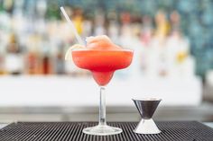 a red drink sitting on top of a metal table