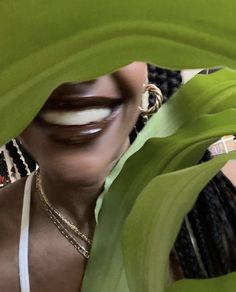 a woman with her mouth open looking through the leaves